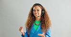 Happy woman, consultant and talking with headphones for call center or customer service on a gray studio background. Young female person or agent consulting for online advice or help on mockup space