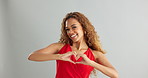 Happy woman, love and support with heart hands for romance or care on a gray studio background. Portrait of female person or model with smile, like emoji or shape for valentines day on mockup space