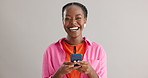 Face, smile or excited black woman with phone in studio for online, competition or giveaway on grey background. Yes, smartphone or female model portrait with app alert of sign up, winner or prize