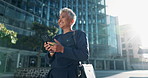 Mature woman, walking and happy with texting on smartphone in outdoor with message. Lens flare, female person and smile with conversation for chat on break with funny meme in street, city and cbd
