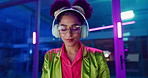 Woman, night and headphones for music, glasses and dancing for motivation in office. Happy female person, hip hop playlist and movement in neon light, connection and streaming radio while working