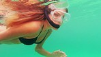 Ocean, underwater and woman scuba diving while on adventure, vacation or holiday in Mexico. Body, water and portrait of female person in bikini snorkeling swimming in the sea on tropical weekend trip