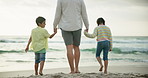 Father, children and holding hands at beach with back, care and connection on vacation in summer. Dad, kids and bonding with love in nature for walk by ocean, waves and sand on holiday with sunshine