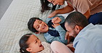 Laughing, tickling and children on bed with parents for fun, relaxing and bonding together at home. Smile, happy and young kids playing with interracial mother and father in bedroom at house.