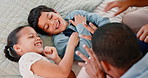 Happy, tickling and kids on bed with parents laughing, relaxing and bonding together at home. Smile, fun and excited young children playing with mother and father in bedroom at modern house.