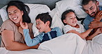 Happy, tickling and children in bed with parents laughing, relaxing and bonding together at home. Smile, fun and young kids resting and playing with interracial mother and father in bedroom at house.