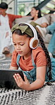 Tablet, education and girl child on living room floor of home for elearning, tutorial or homework. Kids, online study and website with daughter in apartment for research, streaming or browsing