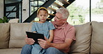 Girl, grandpa or tablet as gaming, app or technology as online, learning or fun on sofa in home. Happy, elderly man or child at touch screen to play, browse or laugh in elearning, bonding or together