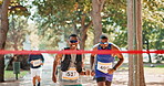 Athlete, running and finish race with ribbon celebration or wellness fitness in forest or challenge, performance or workout. Man, victory and trail in woods or outdoor health, cardio or competition
