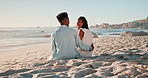 Couple, sitting and beach with talking, back and hug for love, bonding and connection on vacation. Black woman, African man and happy for embrace in conversation, relax or holiday by ocean in summer