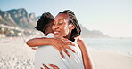 Couple, hug and smile in beach for vacation, holiday and date in city of Cape Tow, fun and peace. Partners, black man and woman embrace with love, outdoor and sea in nature with mountain and happy