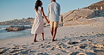 Love, beach and couple holding hands and walking together for bonding, relax and relationship. Dating, travel and happy man and woman by ocean for romantic holiday, vacation and weekend in nature