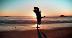 Sunset, love and couple hug at a beach with kiss, support or lifting in celebration in nature. Sunrise, romance and silhouette of people at sea excited for proposal, announcement or surprise question