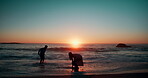 People, sunset and silhouette of couple at beach, ocean and sea playing in water for fun, bonding and summer. Shadows, man and woman with love together on vacation, holiday and travel in Cape Town