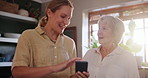 Phone, conversation and woman with senior mom helping on social media, app or internet. Discussion, technology and female person talking, bonding and explaining cellphone to elderly mother at home.