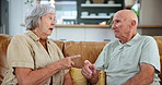 Senior couple, fight and talking in home living room for argument, conflict or divorce. Elderly man, woman and breakup for problem on sofa, conversation or marriage fail with crisis for relationship