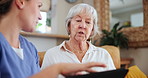 Medical, tablet and nurse talking to old woman on sofa in living room of home for consulting or help. Healthcare, trust or technology and caregiver with senior patient in assisted living apartment