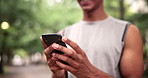 Hands, phone and fitness man in a park with social media, chat or location search in nature. Smartphone, closeup or male runner in a forest online for navigation app, internet or exercise blog update