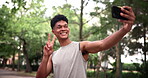 Man, selfie and exercise outdoor with peace sign for online social media post for running, workout or training. Male person, cellphone and hand gesture in forest for fitness challenge, walk or health