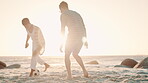 Happy friends, running or playing soccer by ocean on vacation, sun and bonding together on adventure in nature. Men, woman and people with diversity for football game, picnic and exercise on sea sand
