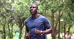 Fitness, running and black man with earphones in nature for outdoor morning workout in woods. Health, wellness and streaming music with athlete in park for muscle exercise, training or body challenge