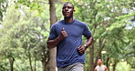 Exercise, running and black man with earphones in park for outdoor morning workout in woods. Health, wellness and streaming music for athlete in nature for muscle fitness, training and body challenge