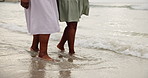 Women, feet and together at beach with waves, water and outdoor for walking with wellness by ocean. People, friends or family with bonding, connection and steps on ground for holiday, nature and sea