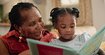 Grandmother, child and reading a book for storytelling, home and fiction in living room. Black family, love and bonding on literature or literacy, happy and fairytale for education and language