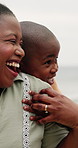 Son, child and mother with embrace on beach for bonding, playing and affection with happiness and talking. Black family, mom and kid by ocean with love, care and hugging on holiday, relax or vacation