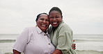 Happy, mother and daughter hug at beach with love and happiness on holiday or vacation together. African, family and portrait of mature mom in embrace with woman at ocean with kindness and support