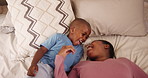 Mother, young boy and top view in bedroom with playing for bonding, jumping and laughing with weekend break in home. Black family, mom or son and happy on bed for game and holiday energy in morning 