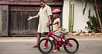 Mother, child on bicycle for outdoor learning, support and helping in neighborhood or street for balance and fun. African family, mom and boy or kid on bike for cycling and teaching in safety helmet