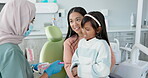 Child, dentist or education of brushing teeth in office or family friendly demonstration of tooth hygiene. Girl, parent or pediatric orthodontist with dental model to brush or lesson on mouth care