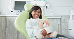 Face, dentist chair and girl with teddy bear, kid and smile with wellness and oral hygiene. Portrait, person and child with a toy and stuffed animal with checkup and appointment with dental care