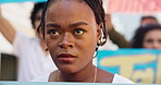 Black woman, crowd and people protest in city for change, justice or human rights with serious face of person. Group, action and riot outdoor for equality with sign, politics or revolution at a rally