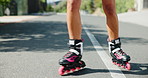 Roller blade, feet and person with fun in the street for travel, adventure and learning or outdoor activity. Closeup or zoom of a legs with rollerblading hobby on asphalt road for journey and balance