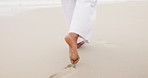 Person, feet and walking on wet sand at beach, footprints and relax journey on summer vacation. Travel, tourist and bare foot  in nature at coast, wellness and holiday adventure by ocean in cape town