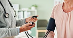 Doctor, hands and patient with blood pressure machine for exam or monitoring heart rate at the clinic. Closeup of person, cardiologist or medical worker measuring pulse for hypertension or healthcare