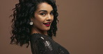 Face, hair and fashion with woman in makeup, sparkle dress and cosmetics with energy on brown background. Stylish clothes, portrait and haircare with curly hairstyle and red lipstick in studio