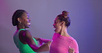 Women, friends and dancing to music in studio with neon light or glitter cosmetics or connection, bonding or purple background. Female people, happy and mockup or techno, fashion or stress relief