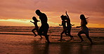 Silhouette, ocean and friends running at sunset for summer vacation, holiday and travel together outdoor. Beach, dusk and group of people at sea water for adventure, party and having fun in nature
