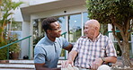 Old man, wheelchair and caregiver outdoor conversation for medical support at clinic, person with a disability or assistance. Volunteer, patient and communication in retirement or care, chat or help