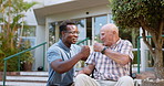 Senior, man and doctor with fist bump in wheelchair for support, greeting and compassion for retirement with smile. Elderly, patient and healthcare professional with hand gesture, happiness and care