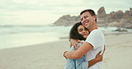 Love hug and couple at beach on holiday, vacation or travel for romantic date together. Smile, happy and young man and woman hugging and having fun by ocean or sea on tropical weekend trip in Mexico.
