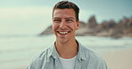 Face, smile and man on beach in summer for travel, holiday or vacation on tropical coast. Portrait, laughing and funny with young tourist on island by ocean or sea for fresh air and weekend getaway