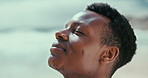 Thinking, beach and black man with vacation, peace and peace with tropical island and adventure. Person, outdoor and seaside with guy and travel with ocean and smile with water, waves or getaway trip