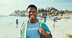 Portrait, volunteer and man at beach for cleaning trash, recycling and environment conservation. Face, charity and smile of African person at ocean for community service, ecology and bag for rubbish