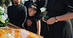 Coffin, family and child at graveyard for funeral, memorial service of burial with empathy, support and flowers. Death, grief and people at casket at cemetery with sympathy, care and goodbye together