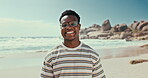 Beach, smile and black man on sand to relax for travel, holiday or vacation on tropical coast. Portrait, nature and happy young tourist on island by sea for fresh air and weekend getaway in summer
