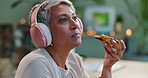 Headphones, pizza and senior business woman for lunch break, eating and dinner in office at night. Professional, creative startup and mature person listen to music, podcast or audio with fast food